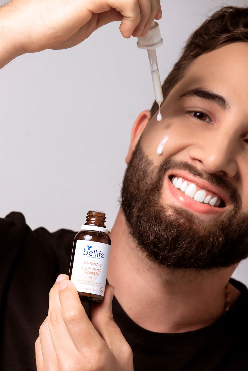 man applying skincare serum to face